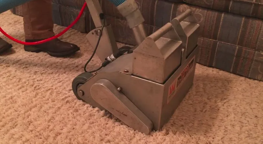 Commercial water extraction equipment removing standing water from carpet in a Garland, TX home