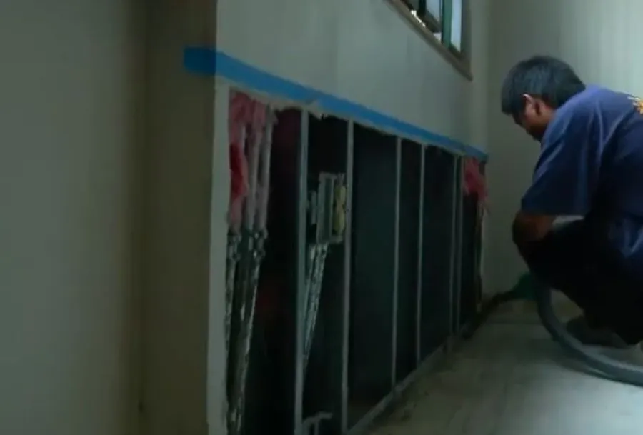 Garland Restore technician drying an opened wall cavity after water removal — equipment and access most homeowners don't have