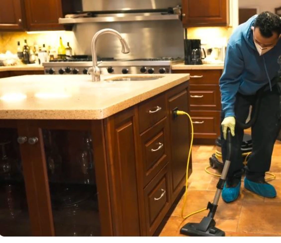Garland Restore technician using a moisture meter on the floor during a water damage assessment