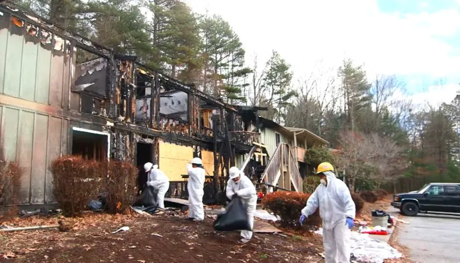 Restoration crew removing fire-damaged debris from a burned property